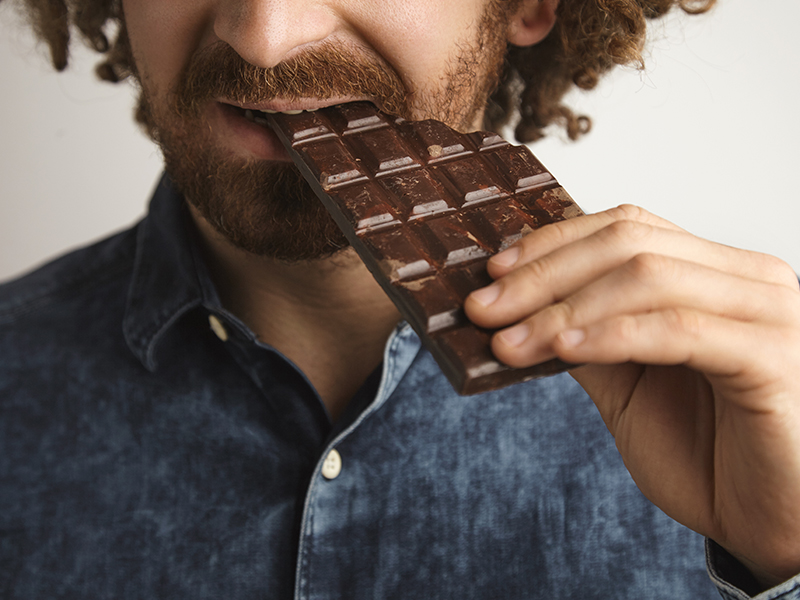 Man running, with dark chocolate as a post-workout recovery snack.