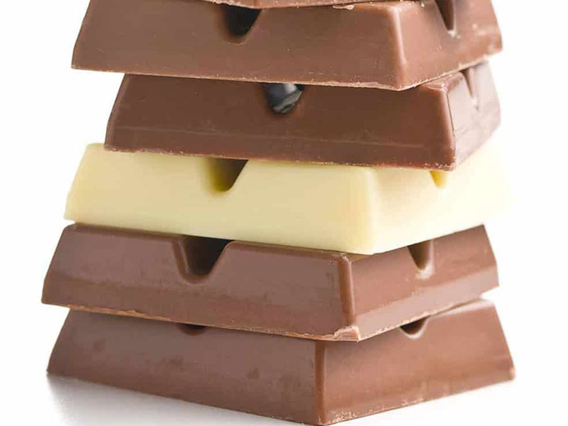 ilk and dark chocolate squares scattered with cocoa beans