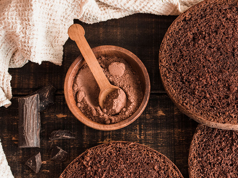 Cocoa powder in bowls with a wooden spoon
